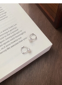 Détails des créoles en argent sterling S925 avec perles sur un livre ancien