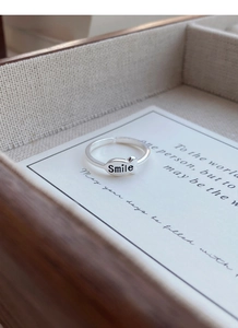 Close-up of S925 silver adjustable ring featuring a smile letter fish charm on a display card