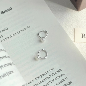 Boucles d'oreilles créoles en argent S925 avec perles d'eau douce sur un livre