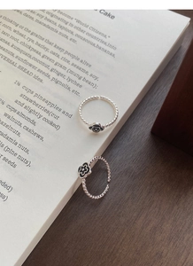 Close-up of S925 silver adjustable rings with black oil-drop flower and twisted band
