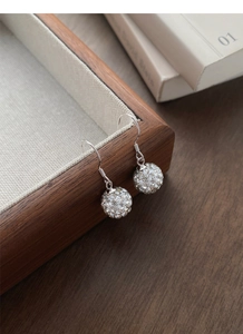 Macro detail of S925 silver hook earrings with shimmering paved zircon ball charms