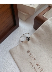 Detailed macro view of S925 sterling silver flower ring on a wooden jewelry box