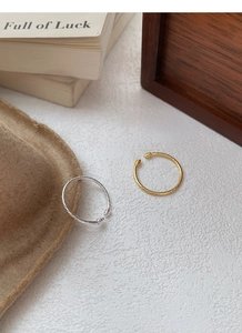 Detail of twisted silver and gold rings with rope texture on a stylish white surface