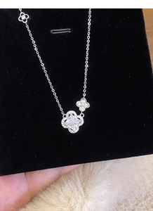 Gros plan d'un pendentif trèfle en argent S925 avec une grande pierre carrée centrale et zircons