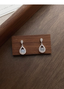 Detailed macro view of S925 silver teardrop earrings with chalcedony and micro pavé crystals