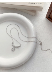 Detailed macro shot of S925 silver necklace with sparkling zircon smile pendant in a white dish