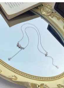 Detail of S925 sterling silver star necklace with tassel and zircon on vintage mirror