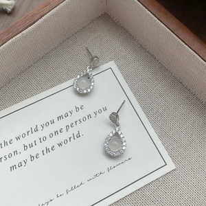 S925 sterling silver teardrop earrings with white chalcedony and zircon on a wooden display