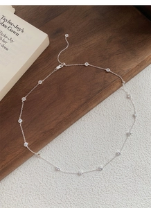 Macro shot of silver S925 necklace featuring circular cubic zirconia and adjustable chain