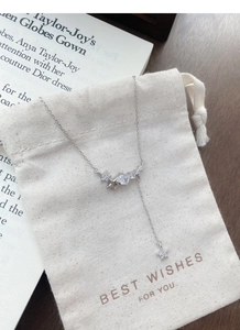 Detailed view of silver star tassel necklace with zircons on a gift bag surface