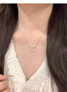 Detail of S925 sterling silver smile necklace with round moonstone and zircon on a model