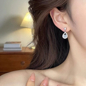 Elegant S925 silver chalcedony teardrop earrings worn by a model in a warm room