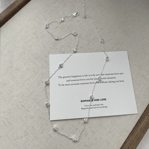 Elegant 925 sterling silver beaded necklace with bezel-set cubic zirconia on a beige tray