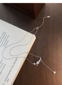 Detail of S925 sterling silver star necklace with sparkling zircons on a book