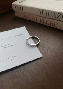 Détail d'une bague ouverte en argent brossé S999 avec zircone sertie en étoile sur bois