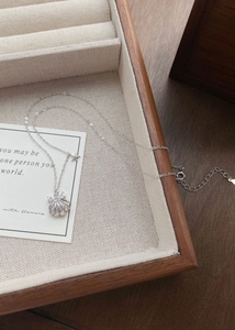 Détail d'un collier en argent S999 avec pendentif coquillage, nœud et petite étoile