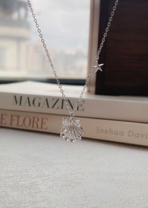 Détail du collier S999 en argent avec pendentif coquillage, nœud en cristal et petite étoile