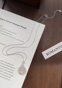 Detailed close-up of S925 silver necklace with white chalcedony pendant and sparkling crystals