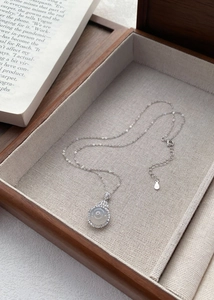Detail of S925 silver necklace with white chalcedony pendant in a premium wooden jewelry box