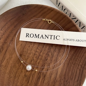 Minimalist S925 silver invisible fish line necklace with pearl pendant on wood decor