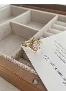 Dettaglio anello vintage in oro con zircone a goccia e perle in scatola di legno
