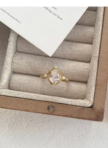 Dettaglio dell'anello vintage in oro con zircone a goccia e perle in una scatola portagioie