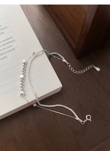 Detail of S925 sterling silver double-layer star bracelet with spring clasp on a book