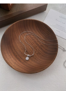 Dettaglio macro della collana nodo in argento S925 con ciondolo di cristallo nel legno