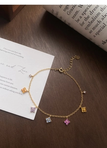 Gros plan détaillé d'un bracelet en argent S925 doré avec cinq trèfles en zircons colorés