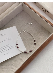 Detailed macro view of S925 sterling silver bracelet with garnet beads and pearls