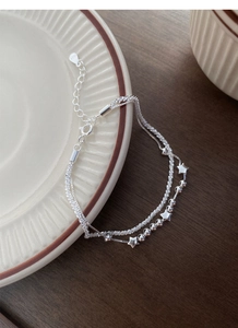 Close-up of double-layer S925 sterling silver star bracelet with shimmering bead chain