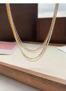 Macro-opname van minimalistische S925 zilveren Chopin- en O-schakelkettingen in goud en zilver