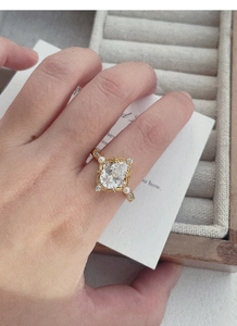 Dettaglio di un anello in stile vintage con zircone a goccia e perle sulla mano