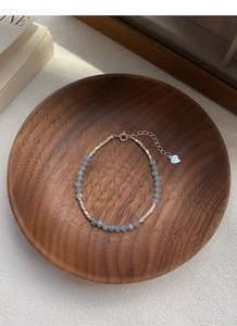 Dettaglio del ciondolo a cuore in argento S925 su bracciale di perline acquamarina