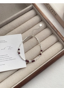 Detail of S925 silver bracelet with garnet beads and natural pearls on velvet tray