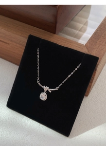 Dettaglio della collana in argento S925 con nodo a fiocco e ciondolo in cristallo quadrato