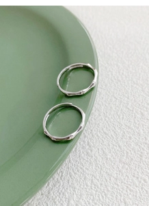Dettaglio ravvicinato degli anelli di coppia in argento S925 con design a nodi di bambù