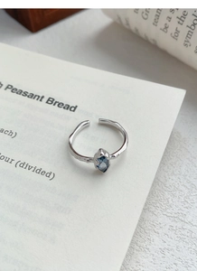 Close-up of S925 hallmark on hammered silver ring with marquise blue sapphire