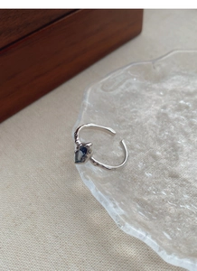 Detail of 925 silver irregular hammered ring with deep blue sapphire gemstone inlay