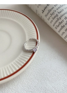 Detail of S925 silver ring featuring irregular hammered texture and purple zircon stone