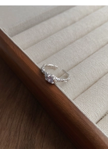 Macro view of irregular texture S925 silver ring with a round purple zircon stone