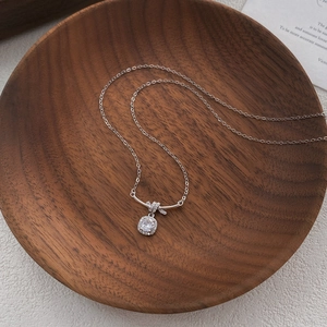 Collana in argento S925 con pendente a cubetto di zucchero e zircone su vassoio in legno