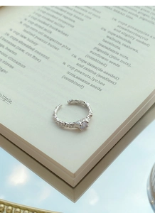 Detail of S925 sterling silver ring with lava texture and heart-shaped purple zircon