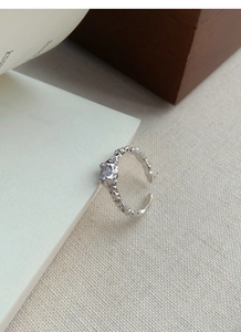 Detail of S925 sterling silver ring with irregular texture and light purple zircon stone