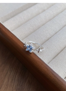 Detail von 925er Silber Sternring mit hellblauem Edelstein auf Holzschmuckkästchen