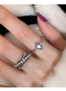 Close-up of stacked 925 sterling silver rings with sapphire zircon on a white fur background
