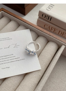 Detailed macro view of S925 silver irregular ring with blue zircon stones in a jewelry box