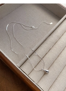 Detailed macro shot of S925 sterling silver necklace with water drop pendant and S925 stamp