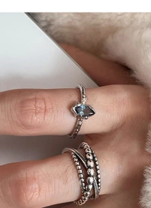 Detail of vintage 925 silver ring set with textured blue sapphire and beaded band