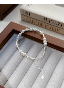Vue détaillée du fermoir et du pendentif S925 sur un bracelet en perles et aigue-marine